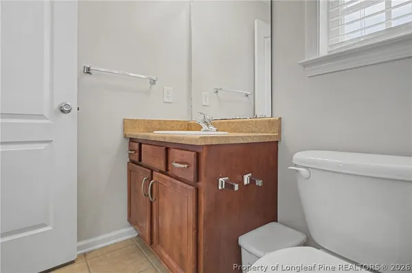 a bathroom with a granite countertop toilet and a sink