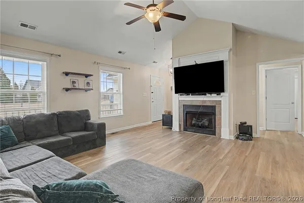 a living room with furniture a flat screen tv and a fireplace