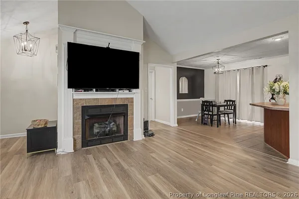 a living room with furniture a flat screen tv and a fireplace