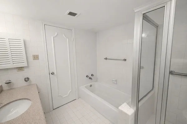 a white bath tub sitting next to a toilet