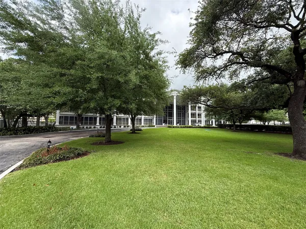 a view of a house with a big yard and large trees