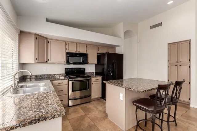 a kitchen with granite countertop wooden cabinets and stainless steel appliances