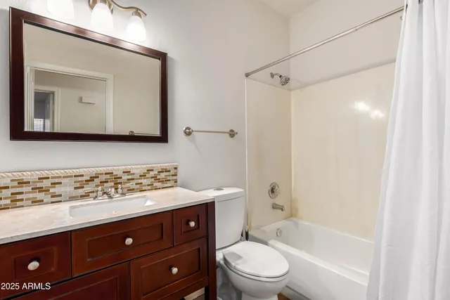 a bathroom with a bathtub shower sink vanity and mirror