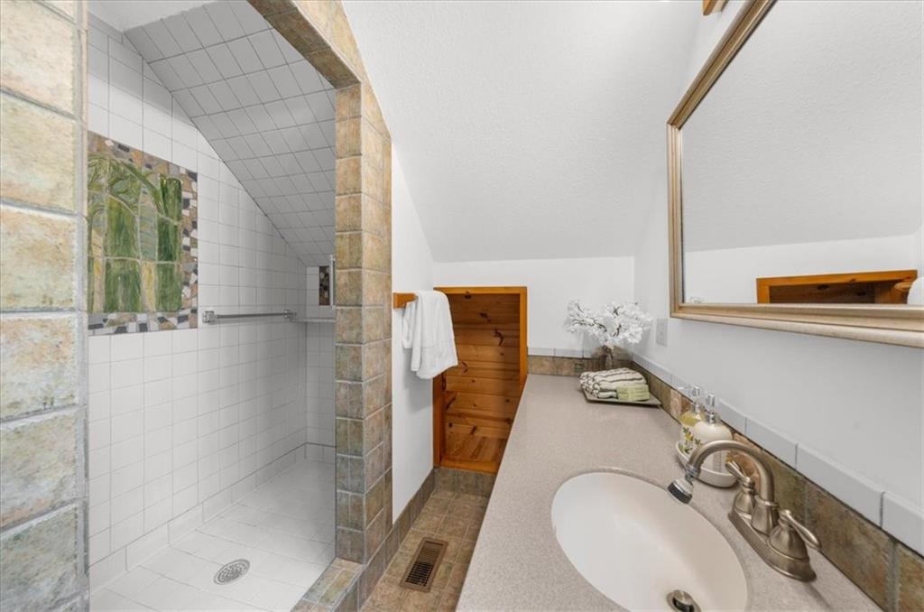 470 Sautee Ridge Road Clarkesville, GA 30523 - Photo 22 of 37 a bathroom with a sink and mirror with bathtub