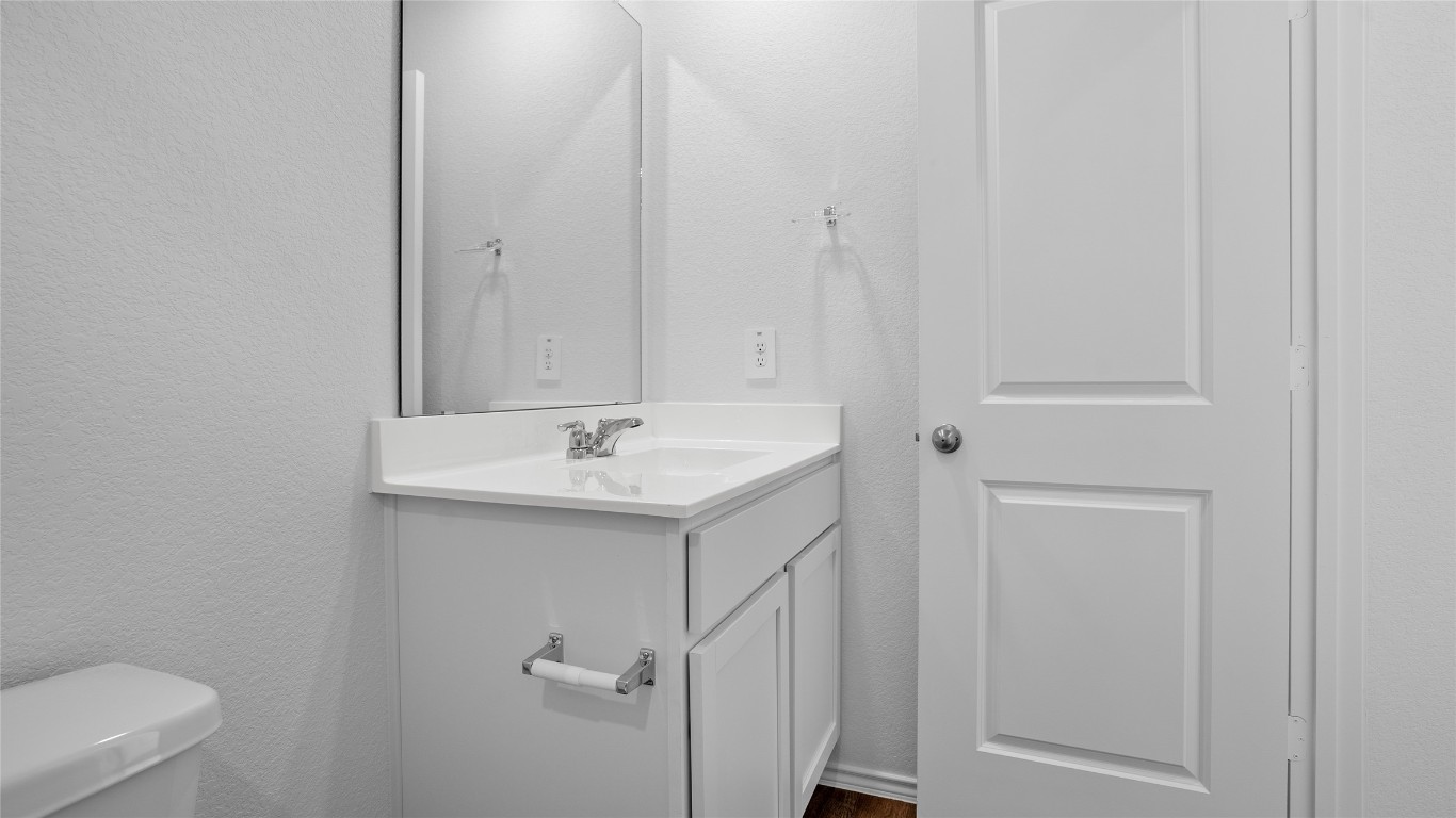105 Celosia Loop Kyle, TX 78640 - Photo 5 of 14 a bathroom with a sink a toilet and a mirror