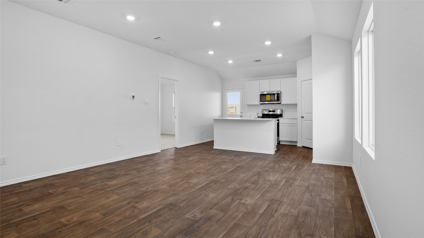 105 Celosia Loop Kyle, TX 78640 - Photo 7 of 14 a view of a kitchen with wooden floor and stainless steel appliances