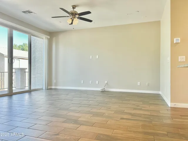 a view of an empty room with window and a kitchen