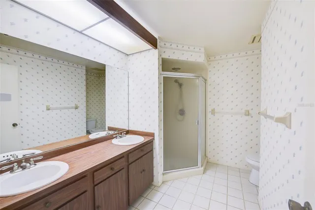 a bathroom with a granite countertop sink a mirror and a shower