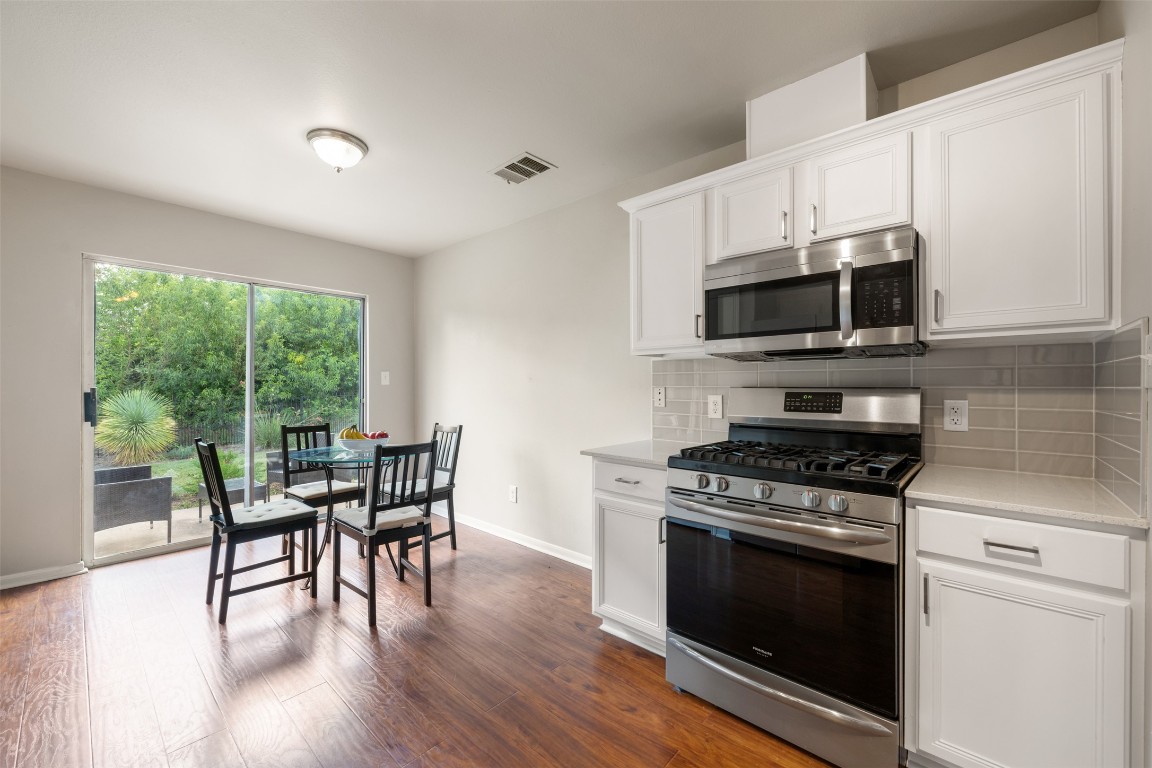 2004 Yaupon Trail Cedar Park, TX 78613 - Photo 14 of 33 a kitchen with a stove a microwave and white cabinets