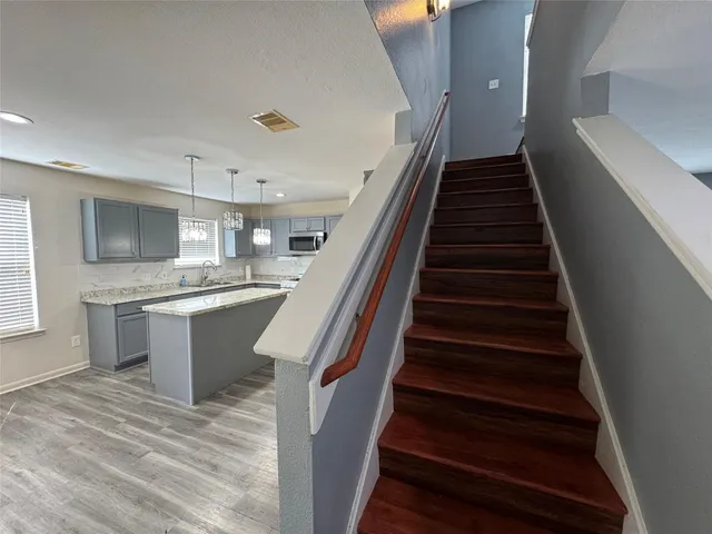 a large white kitchen with wooden floors and a fireplace