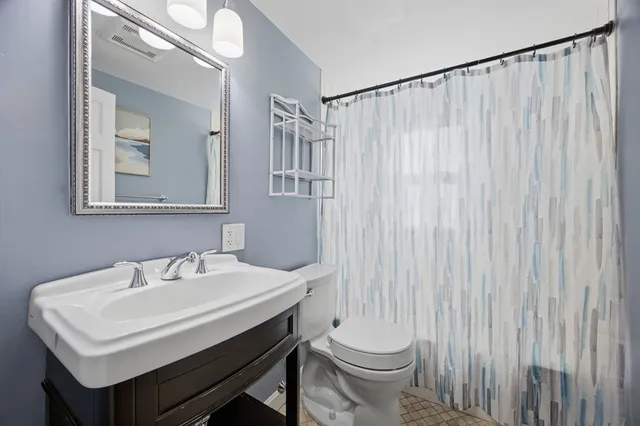 a bathroom with a sink a toilet and mirror