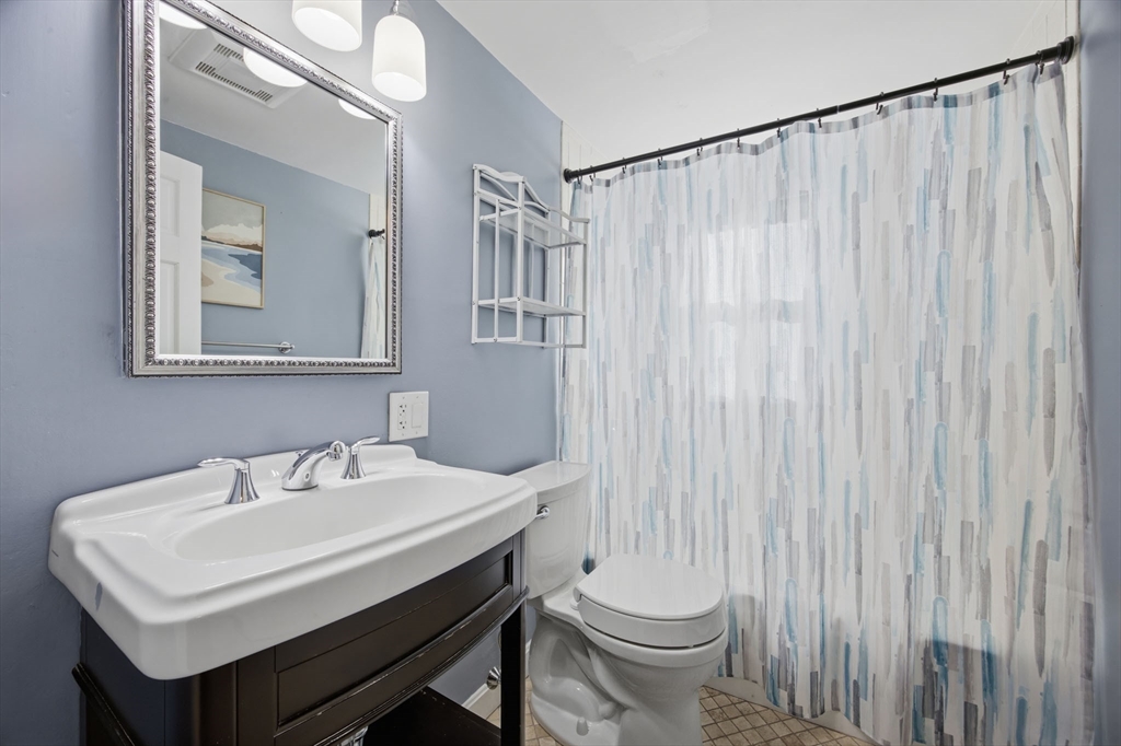 55 Maynard Road Dedham, MA 02026 - Photo 13 of 38 a bathroom with a sink a toilet and mirror