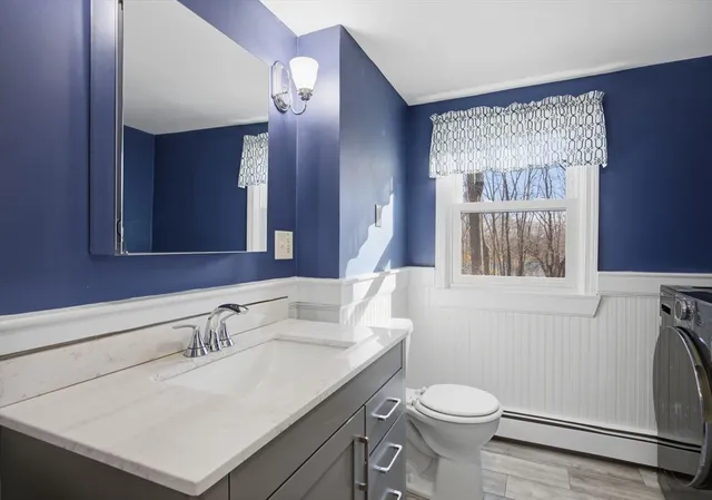 a bathroom with a sink vanity mirror and toilet