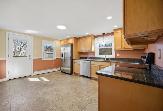 a kitchen with stainless steel appliances granite countertop a refrigerator a sink a stove and oven