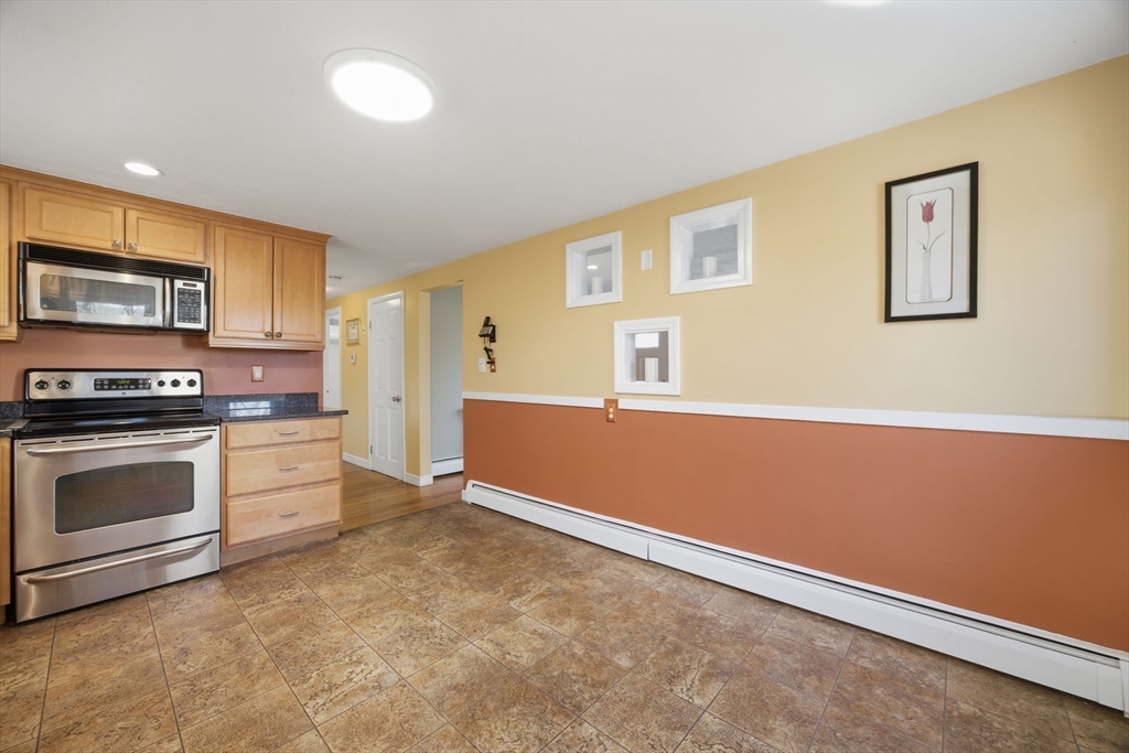 55 Maynard Road Dedham, MA 02026 - Photo 9 of 38 a kitchen with granite countertop a stove and a refrigerator