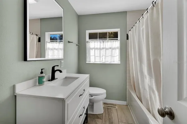 a bathroom with a sink a toilet and a mirror