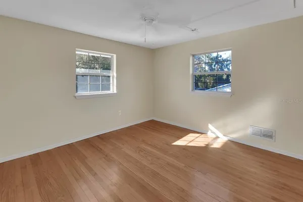 a view of empty room with wooden floor
