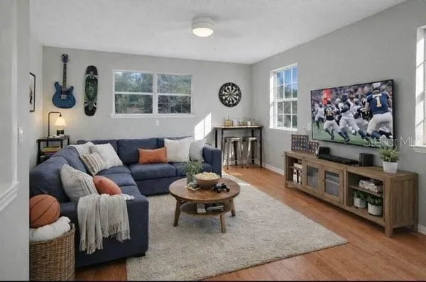 a living room with furniture a window and a flat screen tv