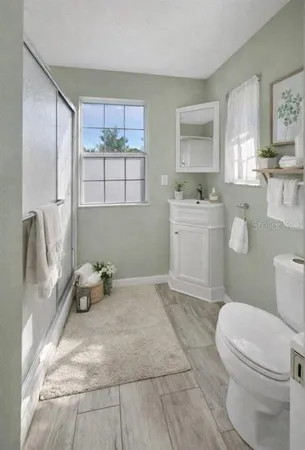 a bathroom with a sink toilet and window