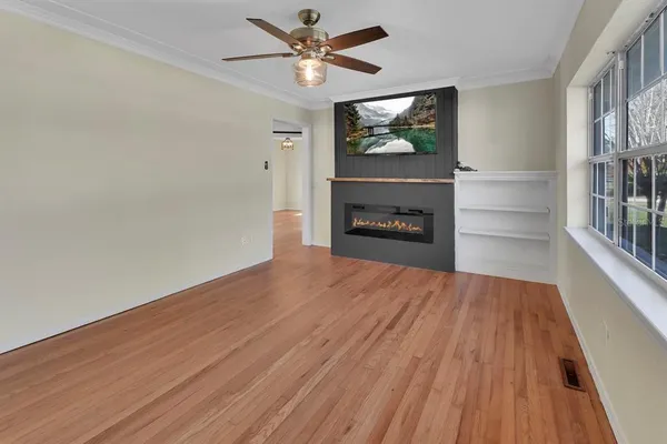 a view of empty room with a fireplace and wooden floor
