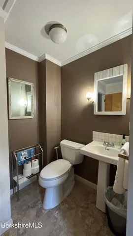 a bathroom with a toilet sink and mirror