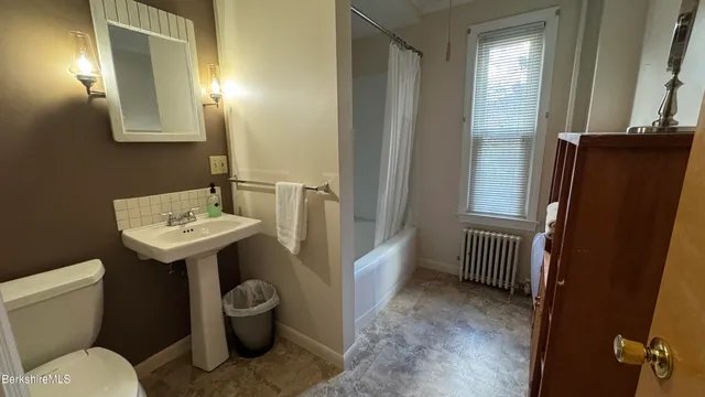 a bathroom with a sink toilet and a mirror