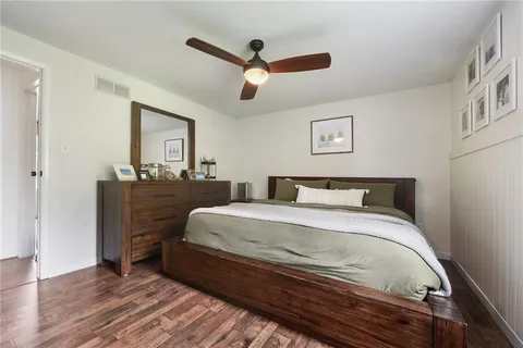 a spacious bedroom with a bed and a dresser