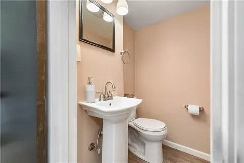 a bathroom with a toilet sink and mirror