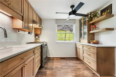 a kitchen with granite countertop a sink a counter space appliances and cabinets