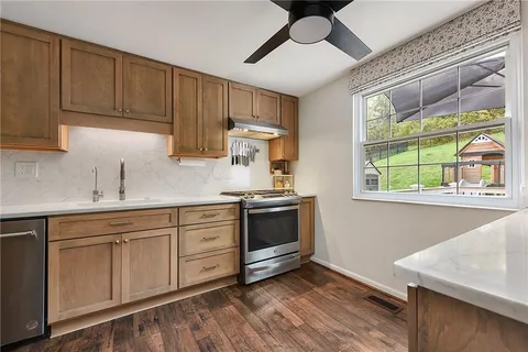 a kitchen with stainless steel appliances granite countertop a stove a sink and a microwave