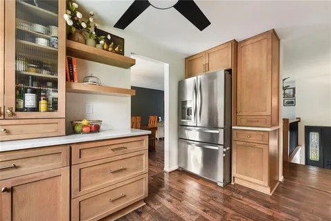 a kitchen with stainless steel appliances a refrigerator and wooden floor