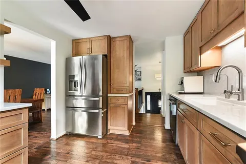 a kitchen with stainless steel appliances granite countertop a refrigerator sink and stove