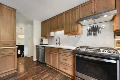 a kitchen with stainless steel appliances a stove a sink and a refrigerator