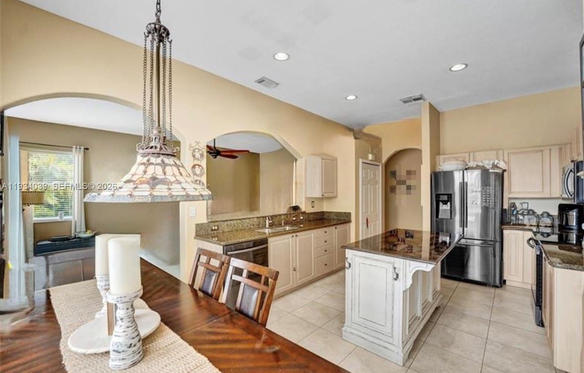 5337 Southwest 131st Terrace Miramar, FL 33027 - Photo 13 of 46 a kitchen with stainless steel appliances kitchen island granite countertop a stove refrigerator and cabinets