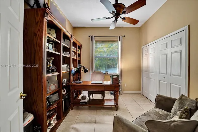 a living room with furniture a bookshelf and a window