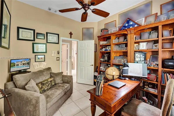 a living room with furniture a bookshelf and a window