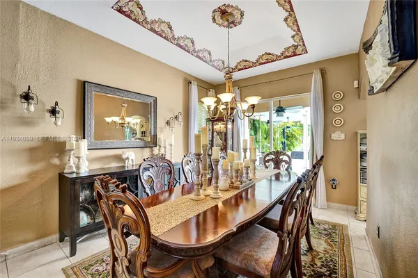 a dining room with furniture a chandelier and wooden floor