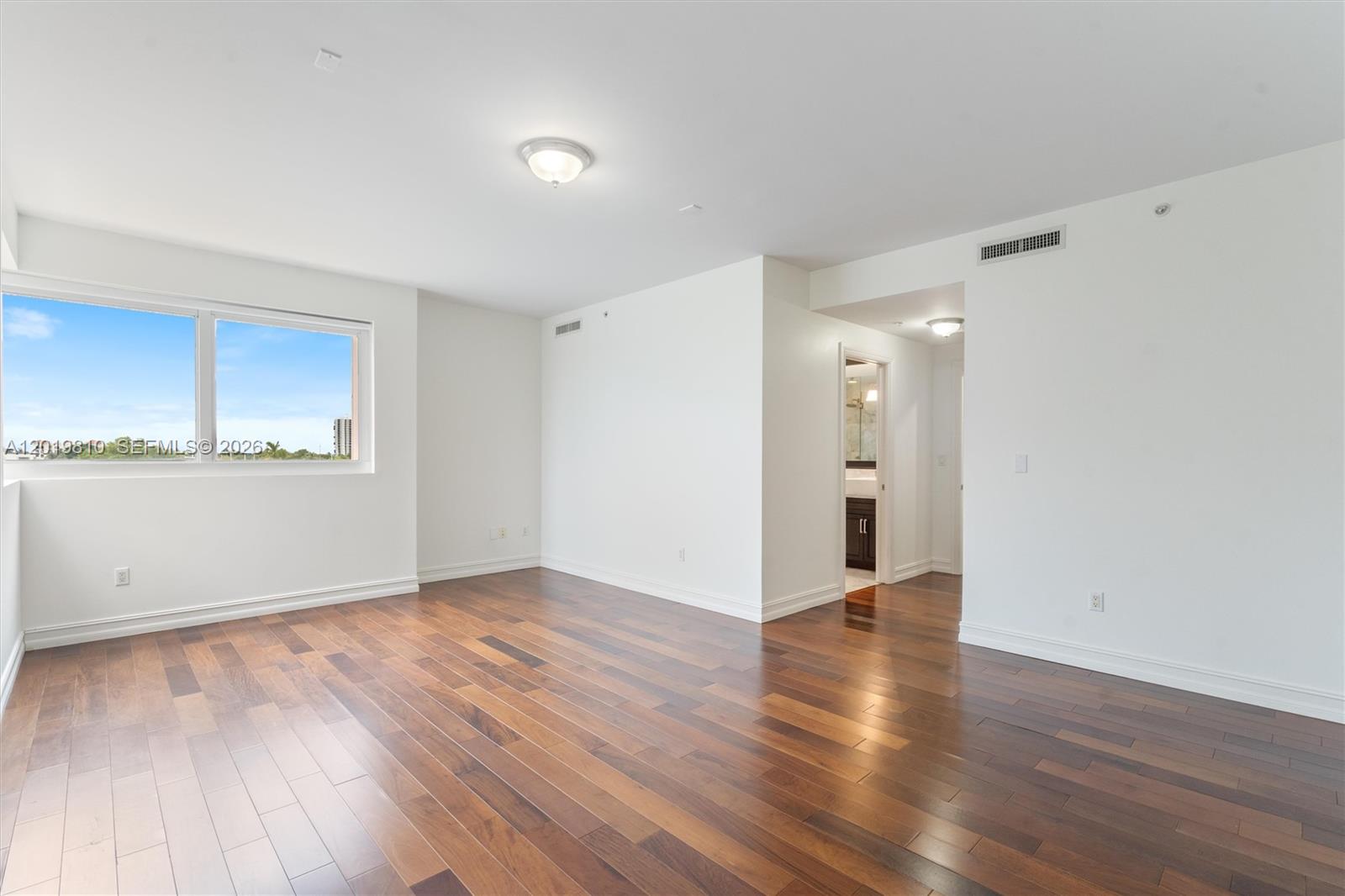 455 East Palmetto Park Road, Unit 4E Boca Raton, FL 33432 - Photo 11 of 30 an empty room with wooden floor and windows