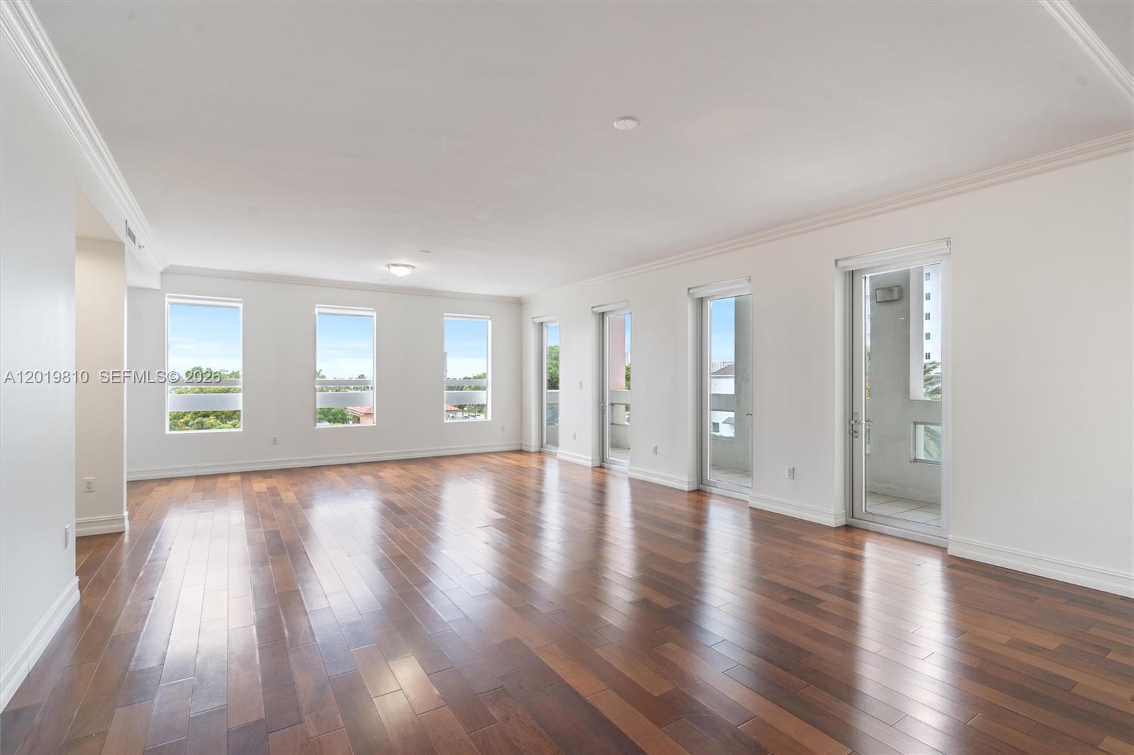 455 East Palmetto Park Road, Unit 4E Boca Raton, FL 33432 - Photo 2 of 30 a view of an empty room with wooden floor and a window