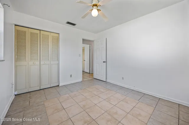 an empty room with chandelier fan