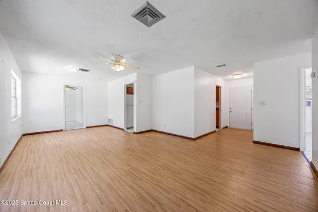 a view of an empty room with wooden floor