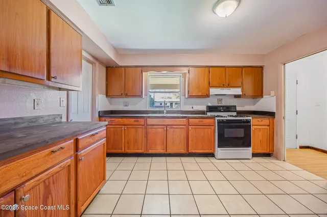 a kitchen with stainless steel appliances granite countertop a stove a sink and a refrigerator