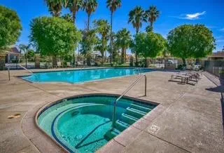 a view of a swimming pool with a patio and a yard