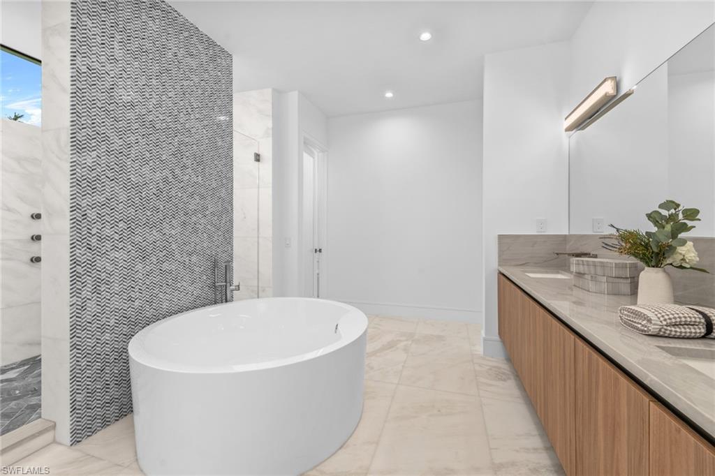 1800 Crayton Road Naples, FL 34102 - Photo 17 of 32 Master Bathroom featuring light marble finish flooring, tiled shower, a freestanding tub, double vanity, and recessed lighting