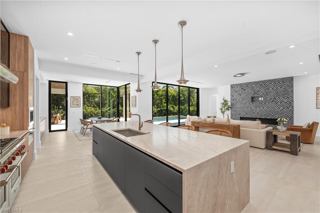 1800 Crayton Road Naples, FL 34102 - Photo 8 of 32 Kitchen featuring modern cabinets, an accent wall, hanging light fixtures, recessed lighting, and a kitchen island with sink