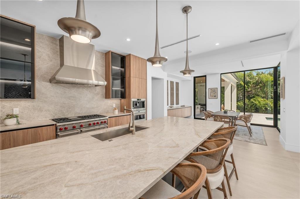 1800 Crayton Road Naples, FL 34102 - Photo 9 of 32 Kitchen with modern cabinets, light stone countertops, tasteful backsplash, and recessed lighting