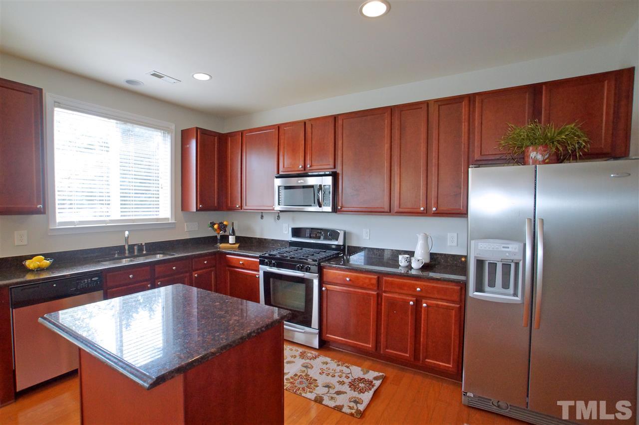 509 Front Ridge Drive Cary, NC 27519 - Photo 13 of 30 a kitchen with stainless steel appliances granite countertop a sink stove and refrigerator