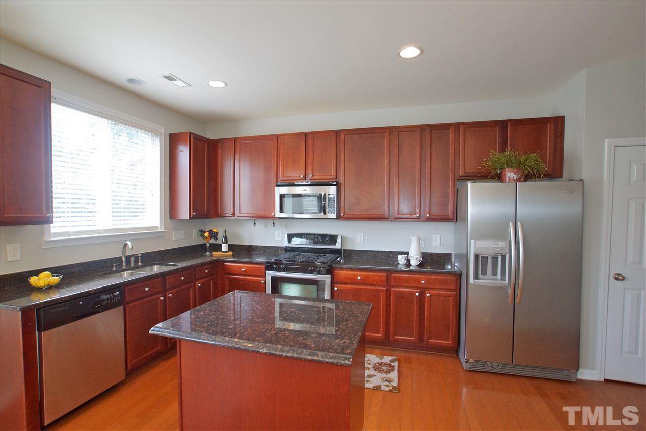 509 Front Ridge Drive Cary, NC 27519 - Photo 14 of 30 a kitchen with stainless steel appliances granite countertop a sink a stove a refrigerator cabinets and a window