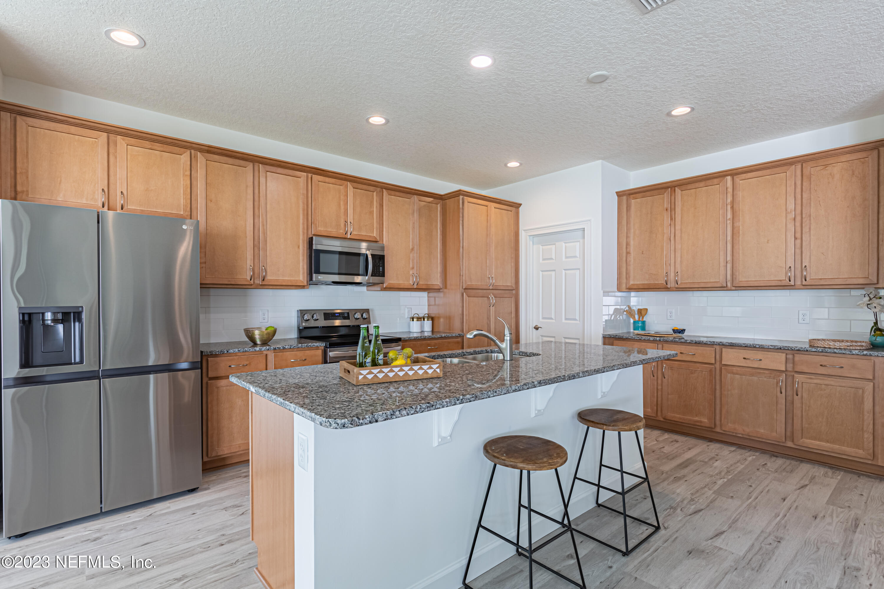 3093 Orange Picker Road Jacksonville, FL 32223 - Photo 15 of 39 a kitchen with granite countertop stainless steel appliances a refrigerator a stove top oven and a center island