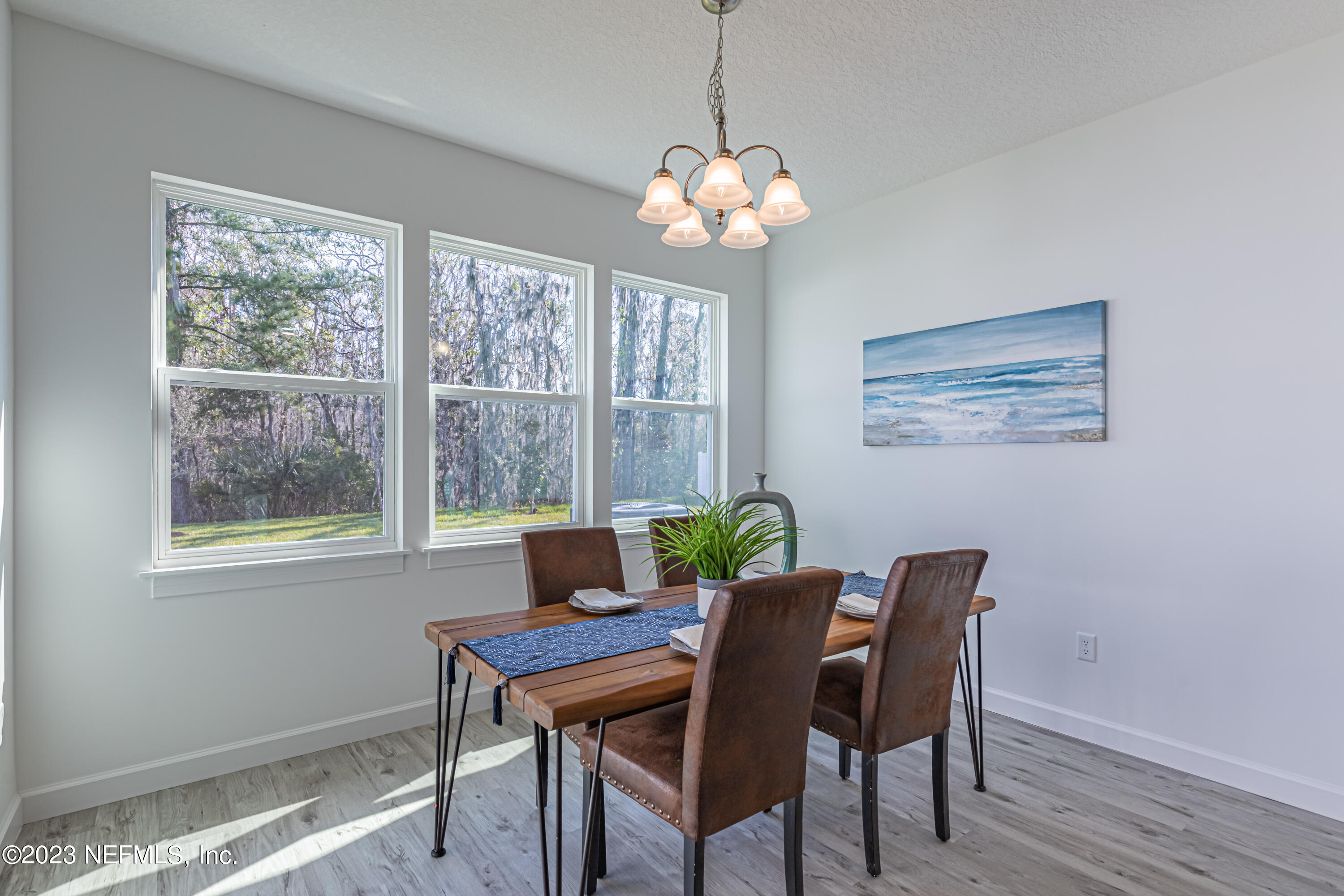 3093 Orange Picker Road Jacksonville, FL 32223 - Photo 17 of 39 a view of a dining room with furniture a chandelier and wooden floor